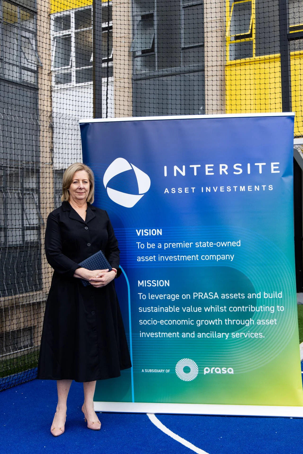 Ms Annette Lindeque standing beside the Intersite Asset Investments banner.