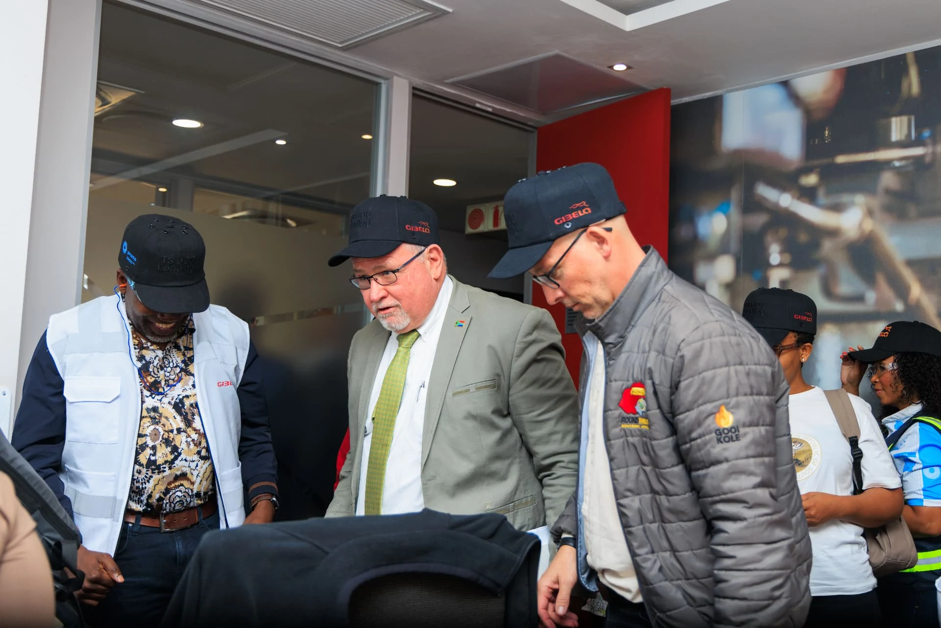 A group gathered indoors, with Gibela branding visible on several caps.